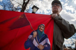 Moscow, Russia. 1st May, 2022. A man holds a banner with a portrait of the Ukraininan babushka with a Soviet Flag during a rally of the Russian Communist Party supporters marking International Workers' Day in Teatralnaya Square in central Moscow, Russia.