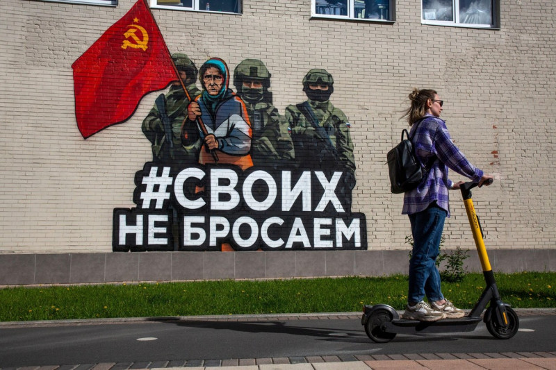 Tula, Russia. 28th May, 2022. A graffitti with a portrait of the Ukraininan babushka with a Soviet Flag, Russian soldiers and the slogan #SvoikhNeBrosaem (Eng: "We don't abandon our own") at a central street in the downtown of Tula, Russia. The Red Banner