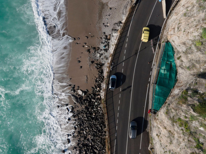 Aerial view of a car driving on the Amalfi drive road facing the Mediterranean sea, Salerno, Italy.