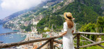 Peaceful woman with white dress and hat enjoying natural landscape from terrace on Amalfi Coast, Italy. Panoramic view. Banner.