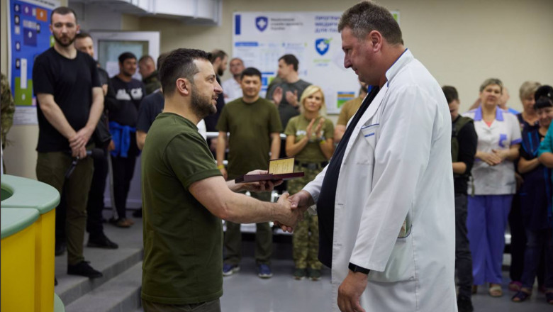 Zelenski salută un medic la Mikoaliv în timp ce personalul privește și aplaudă