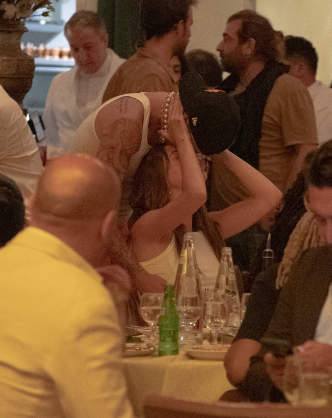 Justin Bieber and Hailey bieber share a kiss while having dinner with friends