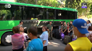 refugiati ucraineni asteptand cu bagaje langa un autobuz