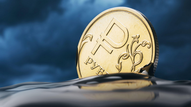 The Russian ruble is drowning in oil against the backdrop of thunderclouds, close-up. Currency fall concept