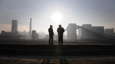Two men discussing in front of a coal mine.