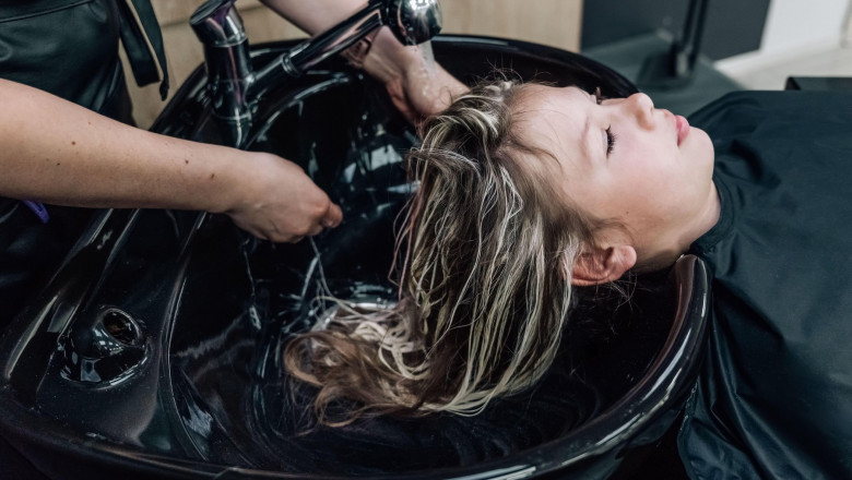 in an elite hairdresser's beautiful young woman washes her head in a special chair. The concept of washing the head in a beauty salon. High quality ph