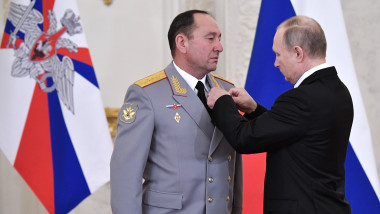 Vladimir Putin (R) awards Maj Gen Gennady Zhidko of the Russian Air Force at a meeting with Russian servicemen