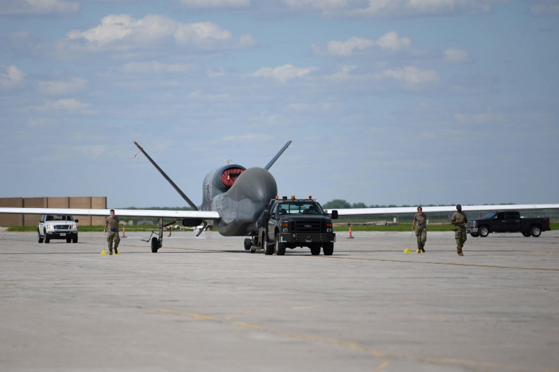Airmen assigned to the 319th Aircraft Maintenance Squadron from Grand Forks Air Force Base, North Dakota, tow an RQ-4 Block 30 Global Hawk remotely piloted aircraft June 6, 2022, across the Grand Forks Air Force Base flight line to Northrop Grumman at Gra