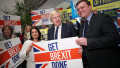 Britain's Prime Minister Boris Johnson (C), Britain's Home Secretary Priti Patel (L) and Conservative candidate Will Quince pose holding a sign before a rally event in Colchester