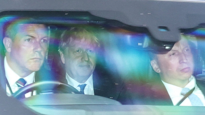 Boris Johnson in masina, in spate, cu sofer si bodiguard pe scaunele din fata