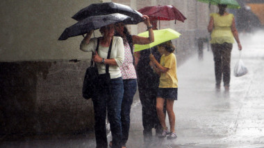 oameni cu umbrele pe strada pe ploaie