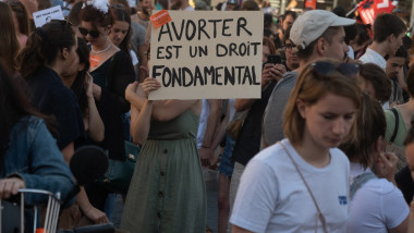 femeie cu pancarta pe care scrie "avortul e un drept fundamental" la proteste
