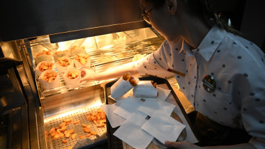 angajată la restaurant scoate cartofi din friteuză