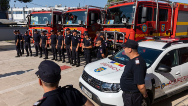 Romanian firefighters stand in front of fire engines during a ceremony, in Athens, on Saturday, July 2, 2022.