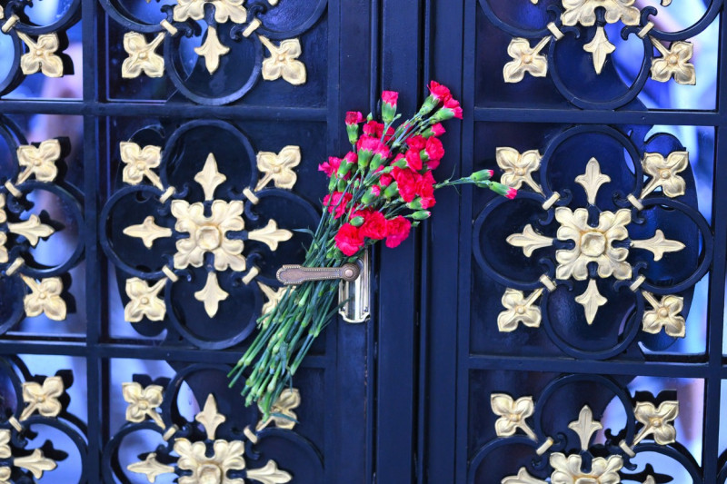 Flowers are left and tv news standing outside Ivana Trumpâ€™s Apartment After The News Of Ivana Passing Away At The Age Of 73