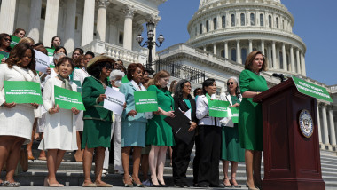 nancy pelosi si mai multe femei in fata capitoliului, imbracate in verde, la un eveniment pt drepturile femeilor