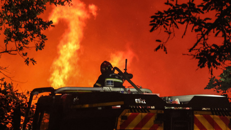 pompier aflat într-o mașină se uită la un incendiu de pădure în regiunea Gironde, Franța