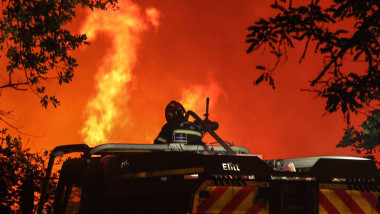 pompier aflat într-o mașină se uită la un incendiu de pădure în regiunea Gironde, Franța