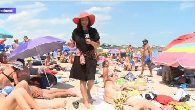 reporter pe plaja din costinesti printre turisti asezati pe prosoape