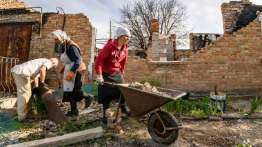 Local residents clean the remains their house destroyed during the Russian occupation of Zahaltsi village near Kyiv