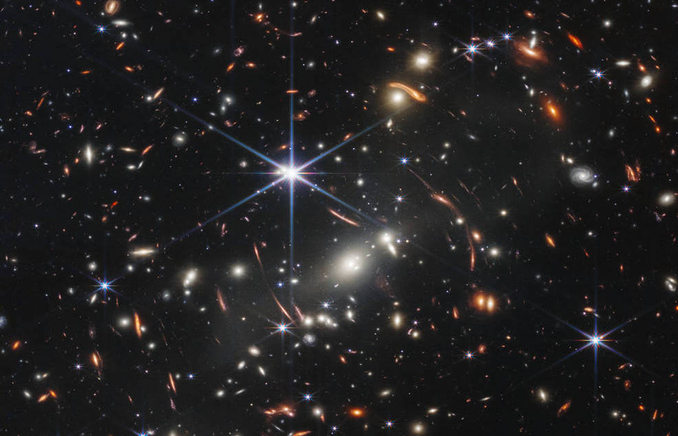 Cum a folosit telescopul James Webb o lentilă cât un roi de galaxii pentru a vedea până aproape de nașterea Universului