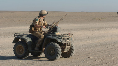 A British Army soldier provides security outside Camp Bastion, Afghanistan, on an ATV equipped with a sniper rifle.
