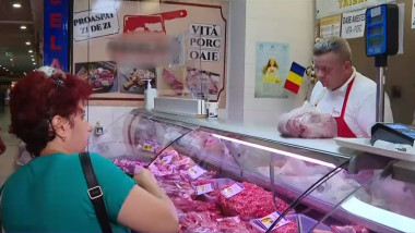 femeie care cumpara dintr-un magazin de carne