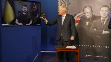 Boris Johnson alaturi de un ecran in care apare zelenski