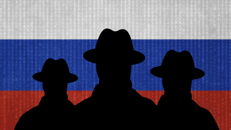 siluete de barbati in negru pe fondul unui steag rus
