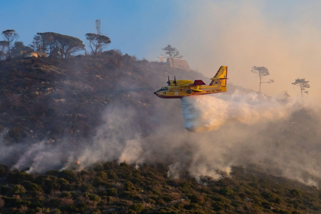 A Viking Air CL415 amphibious water bomber in action to extinguish a wildfire on Monte Moro in Genoa, Italy.