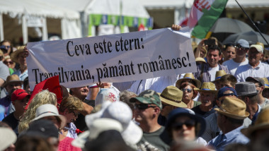 banner cu transilvania pamant romanesc afisat de o persoana aflata in randul multimii care urmarea discursul lui viktor orban la baile tusnad