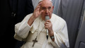 Papa Francisc cu un microfon în mână și cu gesticulând cu cealaltă mână