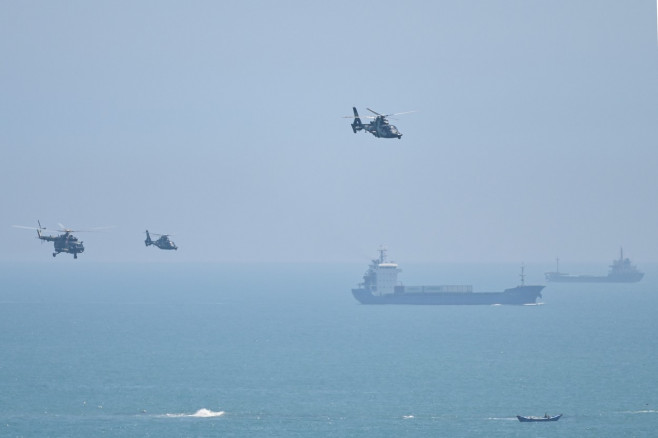 elicoptere militare și un portavion în depărtare