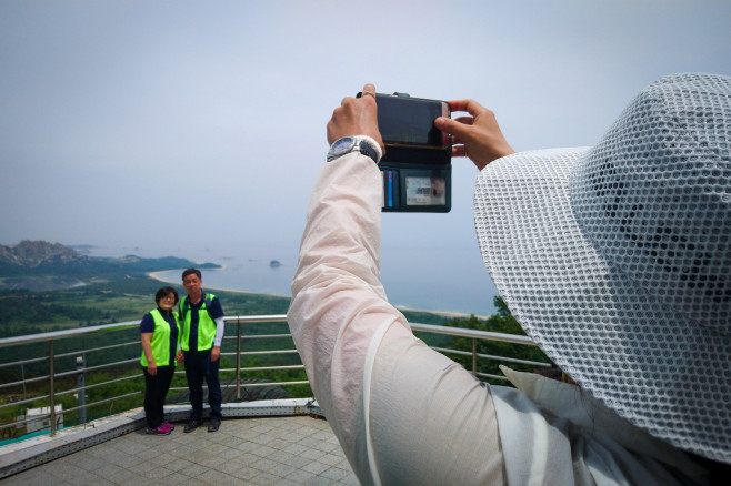 A couple takes a photo with North Korea in the background.