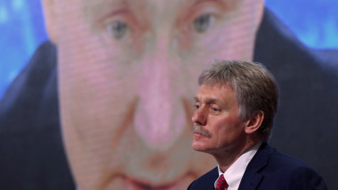 Dmitri Peskov în fața unei proiecții cu Vladimir Putin