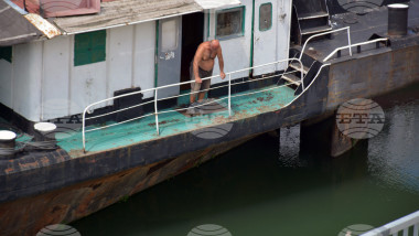barbat care se uita la nivelul apei de pe un vas