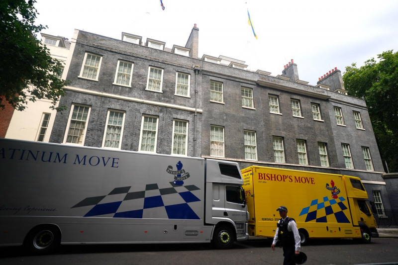 o dubă argintie și una galbenă în fața Downing Street Nr. 10
