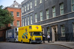 o dubă argintie și una galbenă în fața Downing Street Nr. 10