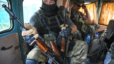 Soldat cu mască și cu o pușcă AK-47 în mână