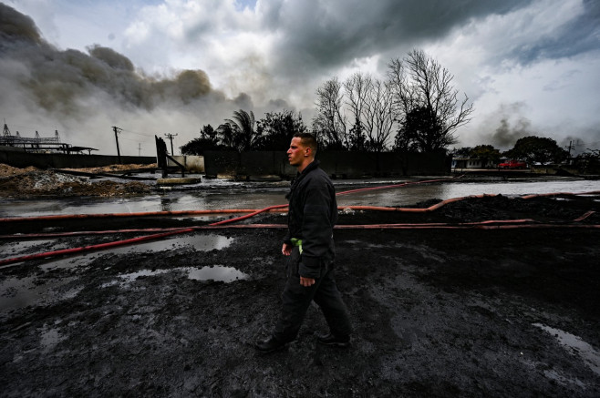 un pompier se plimbă printr-o zonă distrusă de un incendiu