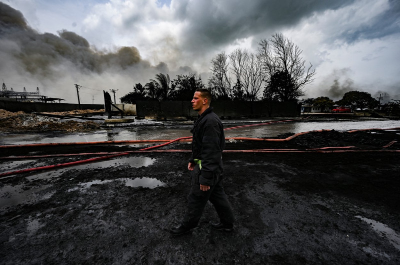 un pompier se plimbă printr-o zonă distrusă de un incendiu