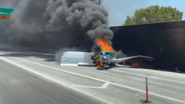 Un avion mic arde pe o autostradă.