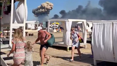 coloane de fum inaltandu-se pe plaja in timp ce turistii fug