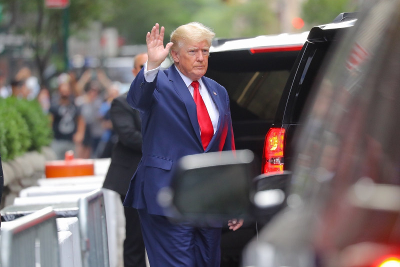 Donald Trump face cu mâna la intrarea într-o mașină