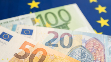 Euro banknotes on EU flag, finance and accounting, banking concept.