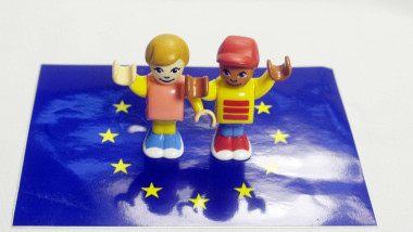 doua figurine reprezentand oameni pe un steag ue