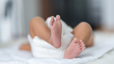 picioarele unui bebelus cu scutec alb