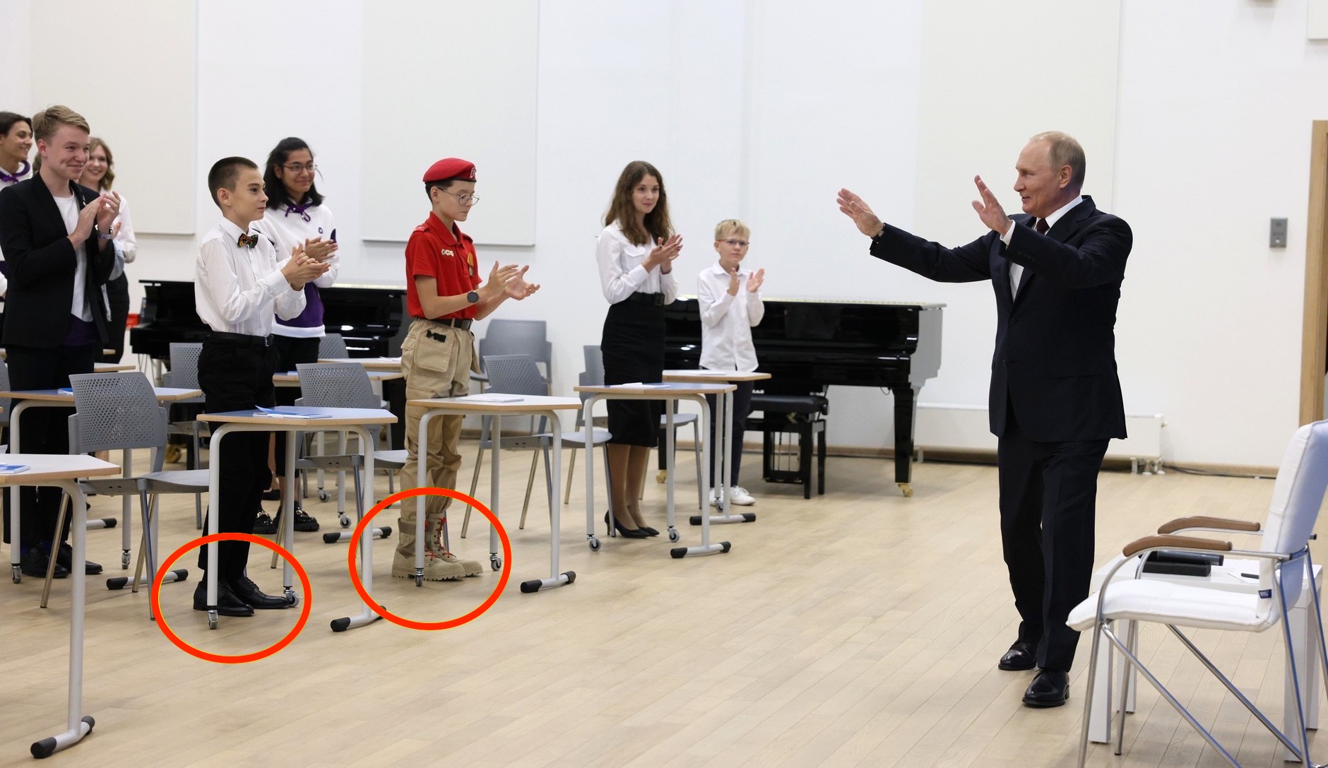 Copii îmbrăcați în uniformă și bocanci cu câteva numere mai mari, aduși la „lecția de istorie” a lui Putin