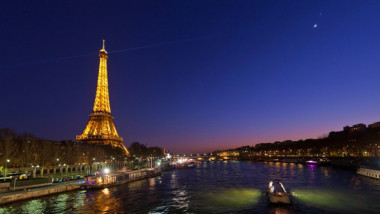 Turnul Eiffel iluminat noaptea.