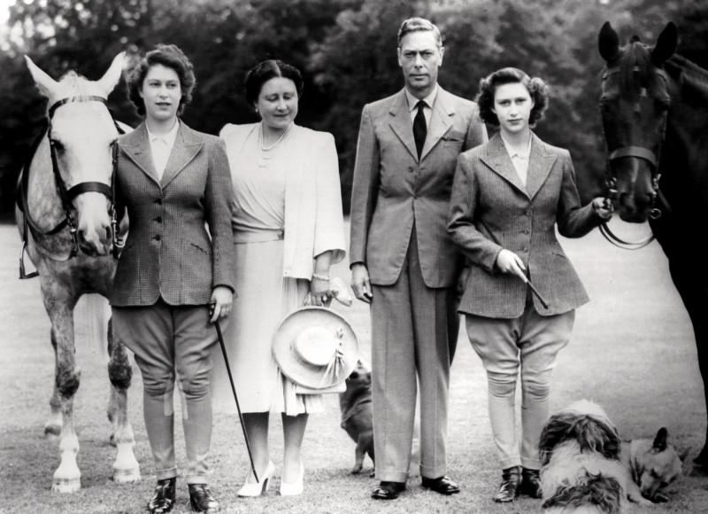 Her Majesty, Queen Elizabeth, The Queen Mother with King George VI and their daughters Princess Elizabeth and Princess Margaret.
Pictured with their favourite dogs and horses at the Royal Lodge, Windsor. Grey horse is Colleen, Black Horse is Shannon, For
